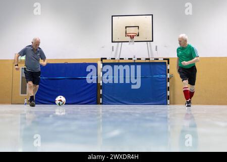 Fußball in Deutschland Göttingen, Deutschland - 26. März 2024: Zwei Senioren tragen Fußballschuhe der Marke adidas und spielen Fußball mit einem offiziellen Spielball für die Euro 2024 in Deutschland mit dem Aufdruck adidas EURO24 Fußballliebe Pro. Niedersachsen Foto Stock