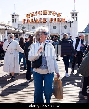 Brighton Regno Unito 30 marzo 2024 - tempo per un gelato sul molo mentre i visitatori godono di una bella e calda giornata di sole sul lungomare di Brighton con più previsioni di sole per la domenica di Pasqua di domani : Credit Simon Dack / Alamy Live News Foto Stock