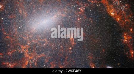 Una delicata trafilatura di polvere e ammassi luminosi si intrecciano a questa immagine del James Webb Space Telescope. Questa vista dallo strumento NIRCam è costellata dalla massiccia popolazione di stelle della galassia, più densa lungo la sua luminosa barra centrale, insieme a nuvole rosse di gas accese illuminate da giovani stelle al suo interno. Queste stelle appartengono alla galassia a spirale barrata NGC 5068, situata a circa 17 metri di distanza dalla Terra nella costellazione Virgo. Questo ritratto di NGC 5068 fa parte di una campagna per creare un archivio di osservazioni della formazione stellare nelle galassie vicine. CREDITI: NASA/ESA/CSA Foto Stock