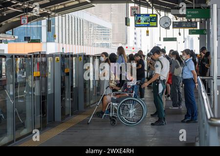 I passeggeri e un anziano su una sedia a rotelle aiutati dal personale della metropolitana sono visti in attesa della monorotaia della linea gialla, sul binario della stazione Lat Phrao, a Bangkok. La monorotaia prodotta dalla multinazionale francese Alstom, di proprietà della Metropolitan Rapid Transit Authority (MRTA) in Thailandia, ha ripreso i servizi della linea gialla dopo che alcune parti sono cadute dall'IT, danneggiando i veicoli ma non causando lesioni. L'incidente è avvenuto due mesi fa, quando una ruota di gomma di un treno della linea gialla è caduta e ha colpito un taxi sulla strada sottostante. (Foto di Nathalie Jamois/SOPA Images/Sipa USA) Foto Stock