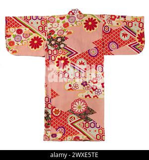 Ritaglio di dettaglio di un kimono miyamairi giapponese con iconografia geometrica e floreale, kimono formale per una ragazza per la prima visita a un santuario shintoista. Sfondo in seta crespata rosa (chirimen) con decorazioni yuzen stincise. Giappone, 1920 - 1940, seta. Foto Stock