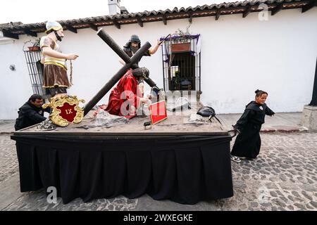 Antigua, Guatemala. 29 marzo 2024. I penitenti cattolici lanciano un galleggiante processionale, parte di una serie di momenti finali di Cristo mentre si preparano per la processione del Santo venerdì del Senor Sepultado Escuela de Cristo durante la Semana Santa, 29 marzo 2024 ad Antigua, Guatemala. L'opulenta processione è una delle più grandi al mondo. Crediti: Richard Ellis/Richard Ellis/Alamy Live News Foto Stock