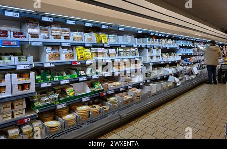 Scaffali di spuntini e cibi pronti da mangiare che si estendono lungo il lungo corridoio del supermercato Lidl Foto Stock