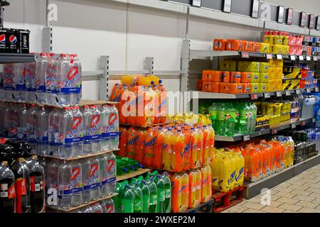 Pile e scaffali di bibite analcoliche in bottiglie di plastica esposte al supermercato Lidl, Spagna Foto Stock