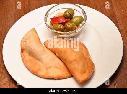 Torta di carne fritta empanada piatto di tapas con ciotola di olive in Spagna Foto Stock