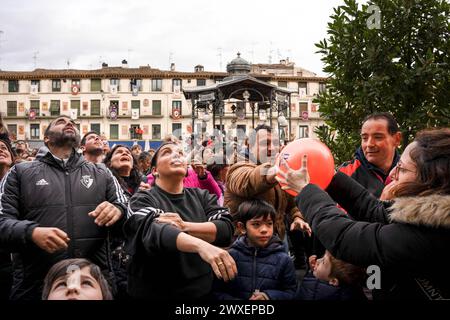 Tudela, Spagna. 30 marzo 2024. Una donna dona una palla d'aria a un uomo durante il lancio di palle nella Plaza de los Fueros a Tudela in occasione della celebrazione di VolatÌn. Centinaia di persone si sono riunite nella Plaza de los Fueros a Tudela, Navarra, per illuminare il tradizionale Volatín, un burattino articolato con elementi pirotecnici all'interno che gira e colpisce un bastone che simboleggia la morte agonizzante di Giuda Iscariota. (Foto di Ximena Borrazas/SOPA Images/Sipa USA) credito: SIPA USA/Alamy Live News Foto Stock