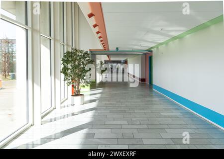 Lungo e luminoso corridoio con grandi finestre e piante verdi nell'ospedale di Herlev. Copenaghen, Danimarca Foto Stock