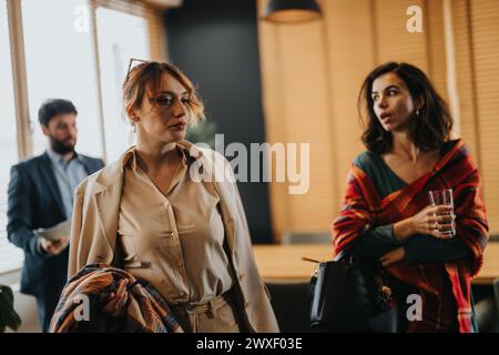 Al termine della giornata lavorativa, i dipendenti stanno lasciando l'ufficio per conversare prima di uscire. Foto Stock