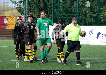 Royal National College for the Blind, Hereford, Regno Unito – sabato 30 marzo 2024 – terza fase della European Blind Football League ( EBFL ) tenutasi presso il Royal National College for the Blind di Hereford, con sei squadre europee. L'arbitro guida la squadra tedesca del Borussia Dortmund BVB all'inizio della partita contro il Pirsos Salonicco della Grecia. Foto Steven May / Alamy Live News Foto Stock