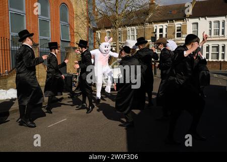 LONDRA, Regno Unito, 24 marzo. La comunità ebraica di Stamford Hill, Londra, celebra il festival religioso di Purim. I ragazzi ballano per le strade e i bambini si vestono con maschere e costumi. Foto Stock