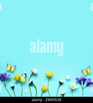 Adagiato con splendidi fiori di prato e farfalla su sfondo blu. Foto Stock