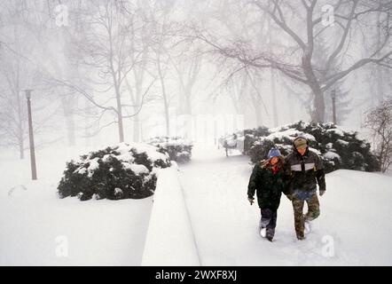 Una coppia di studenti affronta una tempesta di neve invernale nel campus della Pennsylania State University, State College, Pennsylvania; USA Foto Stock