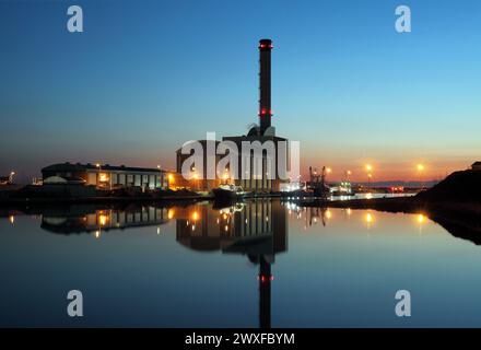 Una vista crepuscolare della centrale elettrica a gas di Shoreham e del suo riflesso nelle acque tranquille del porto di Shoreham. Foto Stock