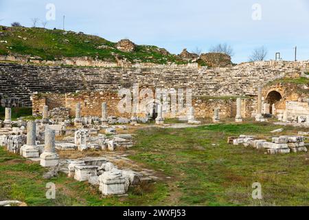 Vista delle rovine delle terme del teatro sullo sfondo dell'antica Odeon nella città greca di Afrodisia nella storica regione culturale della Caria, Turchia Foto Stock