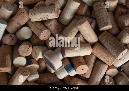 I tappi delle bottiglie di vino si accumulano sulla carta da parati Foto Stock