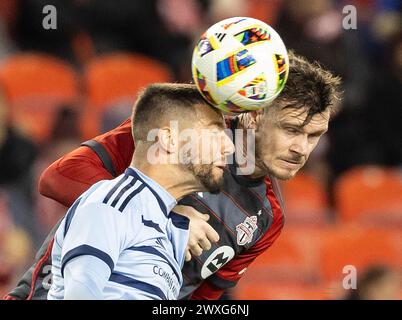 Toronto, Canada. 30 marzo 2024. Kevin Long (tornato) del Toronto FC affronta con Robert Voloder dello Sporting Kansas City durante la partita di Major League Soccer (MLS) 2024 tra Toronto FC e Sporting Kansas City al BMO Field di Toronto, Canada, 30 marzo 2024. Crediti: Zou Zheng/Xinhua/Alamy Live News Foto Stock