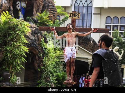 Medan, Indonesia. 29 marzo 2024. Un certo numero di cristiani celebrano il venerdì Santo prima di Pasqua tenendo una via Crucis, dove una delle congregazioni agisce come Gesù Cristo, che sarà crocifisso nel cortile della Chiesa cattolica della Cattedrale di Medan. Credito: SOPA Images Limited/Alamy Live News Foto Stock