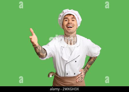 Giovane chef sorridente su sfondo verde Foto Stock