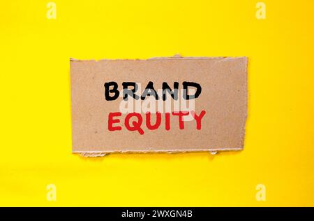 Parole di brand equity scritte su un pezzo di carta strappato con sfondo giallo. Simbolo commerciale concettuale. Copia spazio. Foto Stock