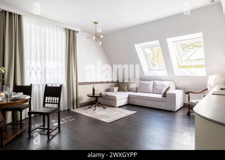 Soggiorno con divano, sedie, tavolo e finestre in una casa Foto Stock