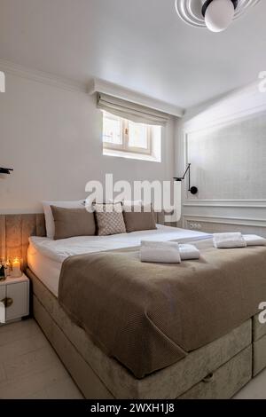 Ampia camera da letto con letto king size e grande finestra Foto Stock