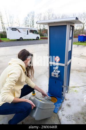 Donna che svuota le acque reflue da un camper Foto Stock