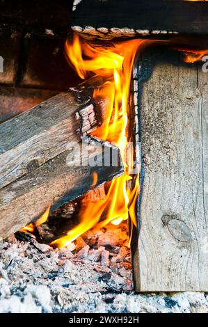 Fiamme, carbone e legna in una fossa per il fuoco di mattoni Foto Stock