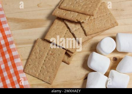 Un tavolo in legno adornato con cracker graham e marshmallow Foto Stock