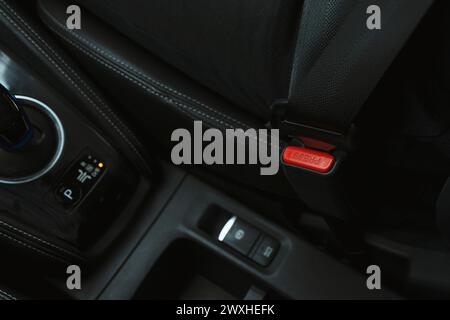 La mano da uomo in primo piano allaccia la cintura di sicurezza dell'auto mentre è seduto all'interno dell'auto prima di guidare e fare un viaggio sicuro Foto Stock