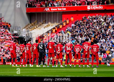 Giocatori e tifosi osservano un minuto di silenzio in memoria dell'ex giocatore del Liverpool Larry Lloyd prima della partita di Premier League ad Anfield, Liverpool. Data foto: Domenica 31 marzo 2024. Foto Stock