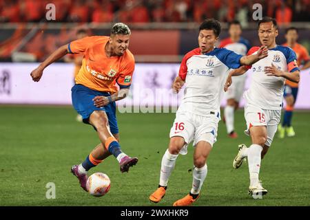 Jinan, la provincia cinese di Shandong. 31 marzo 2023. Cryzan (L) di Shangdong Taishan spara durante il terzo turno della Chinese Football Association Super League (CSL) 2024 tra Shangdong Taishan e Shanghai Shenhua a Jinan, nella provincia di Shandong della Cina orientale, 31 marzo 2023. Crediti: Zhu Zheng/Xinhua/Alamy Live News Foto Stock