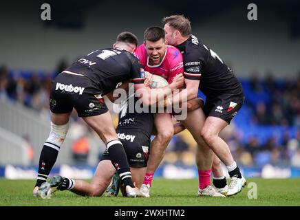 Joe Greenwood degli Huddersfield Giants placcato da Will Lovell dei London Broncos (a sinistra) e Marcus Stock durante il Betfred Super League match al Cherry Red Records Stadium di Londra. Data foto: Domenica 31 marzo 2024. Foto Stock