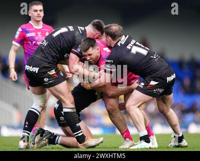 Joe Greenwood degli Huddersfield Giants placcato da Will Lovell dei London Broncos (a sinistra) e Marcus Stock durante il Betfred Super League match al Cherry Red Records Stadium di Londra. Data foto: Domenica 31 marzo 2024. Foto Stock