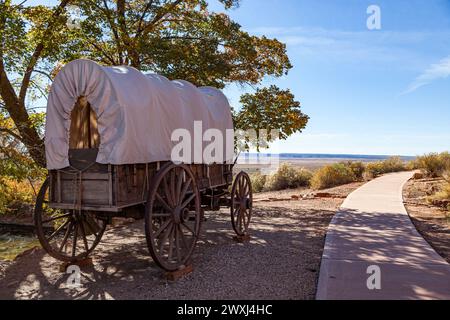 Un vecchio carro coperto in legno in mostra presso il sito storico del Pipe Springs National Monument, accanto a un passaggio pedonale e una vista sul deserto aperto nel di Foto Stock