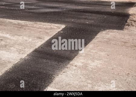 Nuova superficie di asfalto posizionata su un primo piano di strada riparata Foto Stock