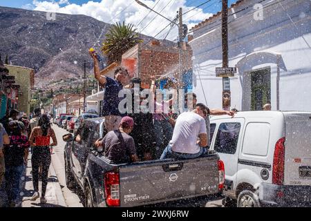 I giovani locali in Un camion spruzzano schiuma sulle persone in strada durante il Carnevale annuale di Tilcara, provincia di Jujuy, Argentina. Foto Stock