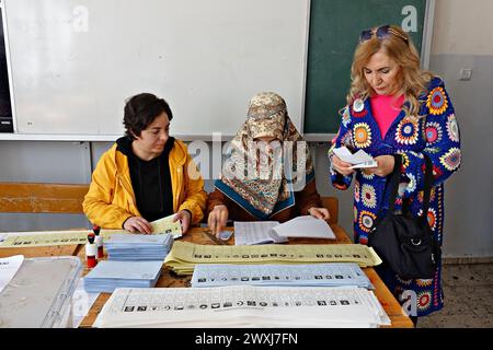 Gli agenti elettorali sono visti controllare l'identità di un elettore durante le elezioni a Diyarbakir. Si vedono votare per le elezioni municipali del 2024 nella città di Diyarbakir, che ha la più grande popolazione curda in Turchia ed è il centro dell'opposizione curda. Nelle elezioni municipali del 2019, l'opposizione curda ha vinto un totale di 65 comuni, tra cui 3 municipalità metropolitane, 5 province, 45 distretti e 12 città. Tuttavia, l’amministrazione statale turca ha nominato fiduciari per 48 di questi comuni. I comuni vinti dai curdi sono stati gestiti da amministratori fiduciari per 8 Foto Stock