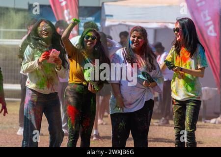 Melbourne, Australia. 31 marzo 2024. Un gruppo di amici si lancia la polvere di colore l'uno contro l'altro durante un evento per celebrare il festival indù di Holi, Melbourne, marzo 2024. Al parco di Docklands, il sobborgo contemporaneo del centro di Melbourne, il festival Holi Blossoms è una vibrante espressione di armonia culturale. Sullo sfondo del verde urbano e dell'architettura moderna, i partecipanti si immergono nelle festività giubilanti, diffondendo gioia e cameratismo. Credito: SOPA Images Limited/Alamy Live News Foto Stock