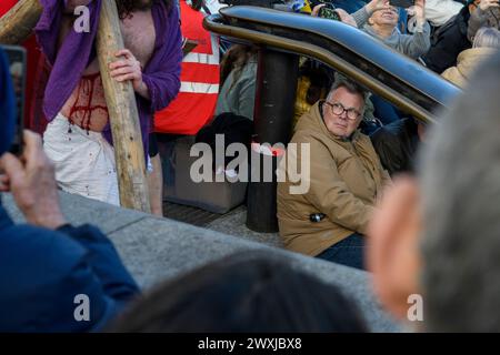 Membro del pubblico che guarda Gesù che porta una croce durante lo spettacolo Passion Play, Trafalgar Square, Londra, venerdì Santo, Pasqua, 2024 Foto Stock