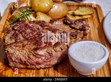 Bistecca alla griglia con patate e sale. Concetto di cucina alla griglia Foto Stock