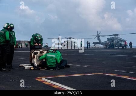 SOUTH CHINA SEA (27 marzo 2024) i marinai statunitensi conducono operazioni di volo sulla piattaforma di volo a bordo della portaerei classe Nimitz USS Theodore Roosevelt, 27 marzo 2024. La Theodore Roosevelt, nave ammiraglia del Carrier Strike Group Nine, sta conducendo operazioni di routine nell'area delle operazioni della 7th Fleet. La U.S. 7th Fleet è la più grande flotta numerata della Marina degli Stati Uniti, e interagisce e opera regolarmente con alleati e partner nel preservare una regione indo-pacifica libera e aperta. (Foto della Marina degli Stati Uniti di Andrew Benvie, specialista di comunicazione di massa di seconda classe) Foto Stock