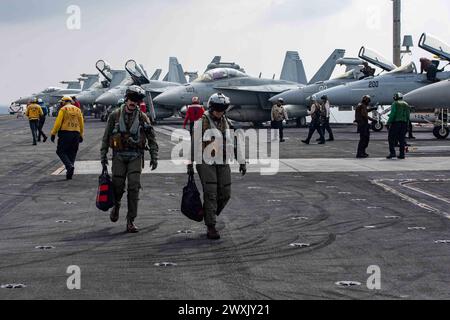 SOUTH CHINA SEA (28 marzo 2024) U.S. Navy tenente Clay Elward (a sinistra), e tenente Amelia Verges, assegnati ai "Black Knights" dello Strike Fighter Squadron (VFA) 154, partecipano alle operazioni di volo a bordo della portaerei classe Nimitz USS Theodore Roosevelt (CVN 71), 28 marzo 2024. La Theodore Roosevelt, nave ammiraglia del Carrier Strike Group Nine, sta conducendo operazioni di routine nell'area delle operazioni della 7th Fleet. La U.S. 7th Fleet è la più grande flotta numerata della Marina degli Stati Uniti, e interagisce e opera regolarmente con alleati e partner nel preservare un Indo-Pa libero e aperto Foto Stock