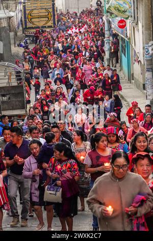 Chichicastenango, Guatemala. 30 marzo 2024. Le donne indigene Maya che indossano huipiles tradizionali conducono una processione a lume di candela che mescola credenze cristiane e Maya il sabato Santo attraverso l'area del mercato fino all'Iglesia de Santo Tomás, 30 marzo 2024 a Chichicastenango, Guatemala. La Chiesa cattolica e le credenze maya si mescolarono molto tempo fa nelle regioni indigene del Guatemala in un processo chiamato sincretismo. Crediti: Richard Ellis/Richard Ellis/Alamy Live News Foto Stock