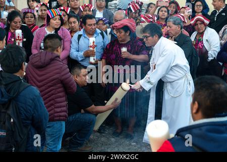 Chichicastenango, Guatemala. 30 marzo 2024. Un sacerdote cattolico accende le candele durante una cerimonia cristiana e maya prima di una veglia a lume di candela per Gesù il sabato Santo al Cementerio De Chichicastenango, 30 marzo 2024, a Chichicastenango, Guatemala. La Chiesa cattolica e le credenze maya si mescolarono molto tempo fa nelle regioni indigene del Guatemala in un processo chiamato sincretismo. Crediti: Richard Ellis/Richard Ellis/Alamy Live News Foto Stock