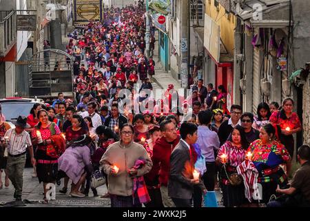 Chichicastenango, Guatemala. 30 marzo 2024. Le donne indigene Maya che indossano huipiles tradizionali tengono una processione a lume di candela che mescola credenze cristiane e maya il sabato Santo attraverso il mercato, 30 marzo 2024 a Chichicastenango, Guatemala. La Chiesa cattolica e le credenze maya si mescolarono molto tempo fa nelle regioni indigene del Guatemala in un processo chiamato sincretismo. Crediti: Richard Ellis/Richard Ellis/Alamy Live News Foto Stock