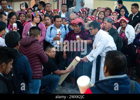 Chichicastenango, Guatemala. 30 marzo 2024. Un sacerdote cattolico accende le candele durante una cerimonia cristiana e maya prima di una veglia a lume di candela per Gesù il sabato Santo al Cementerio De Chichicastenango, 30 marzo 2024, a Chichicastenango, Guatemala. La Chiesa cattolica e le credenze maya si mescolarono molto tempo fa nelle regioni indigene del Guatemala in un processo chiamato sincretismo. Crediti: Richard Ellis/Richard Ellis/Alamy Live News Foto Stock