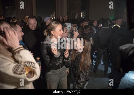 Berlino, dal 31 marzo al 1° aprile 2024 - in un'atmosfera carica di attesa e unità, la porta di Brandeburgo a Berlino emerse come punto focale di un significativo cambiamento sociale nella notte che portò alle prime ore del 1° aprile 2024. Questa storica occasione ha segnato il passo della Germania verso una nuova era nella politica sulle droghe con la parziale legalizzazione della cannabis per uso ricreativo, scatenando una celebrazione collettiva tra la folla riunita. La legge di riferimento, in vigore dal 1° aprile, consente agli adulti tedeschi di possedere e consumare legalmente cannabis, stabilendo limiti di possesso personale fino a 25 gr Foto Stock