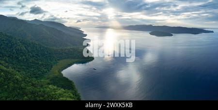 La fitta foresta pluviale copre la costa panoramica di Batanta meridionale, Raja Ampat. Questa regione biodiversificata è conosciuta come il cuore del Triangolo dei Coralli. Foto Stock