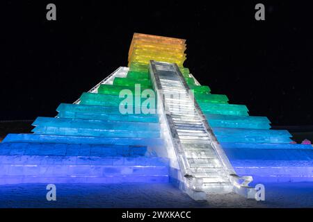 HARBIN, CINA - 1° gennaio 2022: Costruzione di ghiaccio a forma di piramide messicana. Harbin International Ice and Snow Festival. I turisti sono in visita. Loca Foto Stock