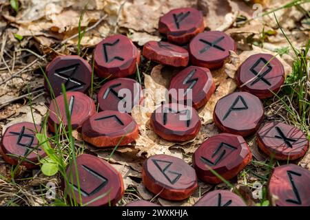 Rune rosse scolpite nel legno sul terreno Foto Stock